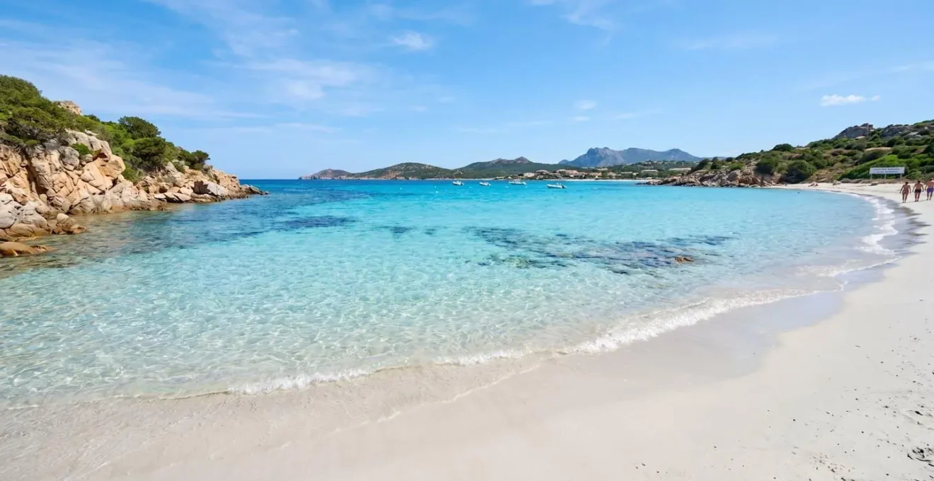Weitwinkelaufnahme eines unberührten Strandes von Golfo Aranci, Sardinien, türkisfarbenes kristallklares Wasser, weisser Sand, mediterrane Küstenlandschaft, sonniger Tag, lebendige natürliche Farben, keine Personen im Hauptfokus