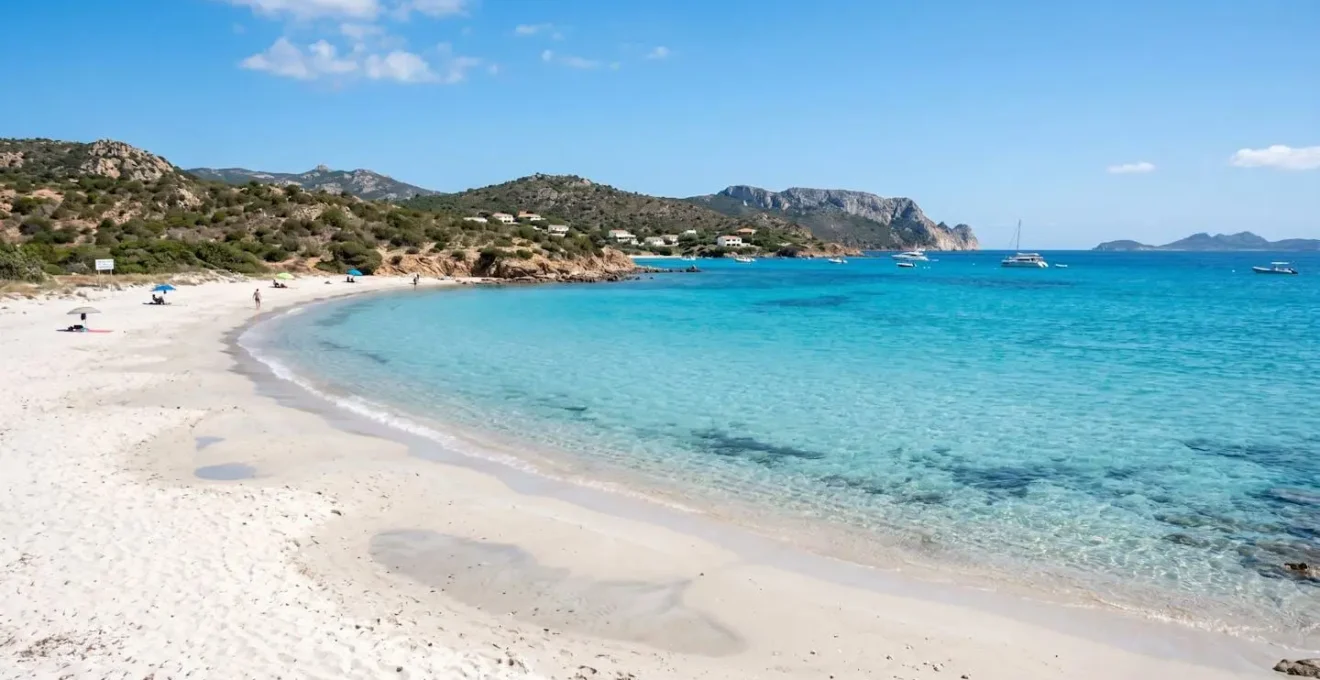 Weitwinkelaufnahme eines unberührten Strandes von Golfo Aranci, Sardinien, türkisfarbenes kristallklares Wasser, weisser Sand, mediterrane Küstenlandschaft, sonniger Tag, lebendige natürliche Farben, keine Personen im Hauptfokus